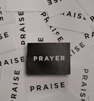 a pile of black and white paper with the word prayer on it