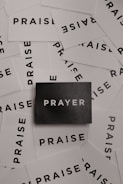 a pile of black and white paper with the word prayer on it