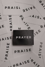 a pile of black and white paper with the word prayer on it