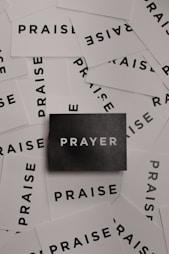 a pile of black and white paper with the word prayer on it