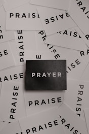 a pile of black and white paper with the word prayer on it