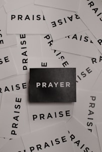 a pile of black and white paper with the word prayer on it