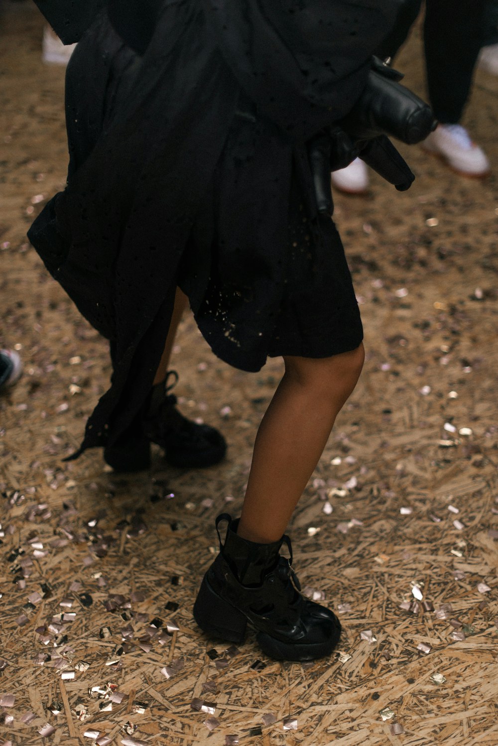 a person in a black outfit and black shoes