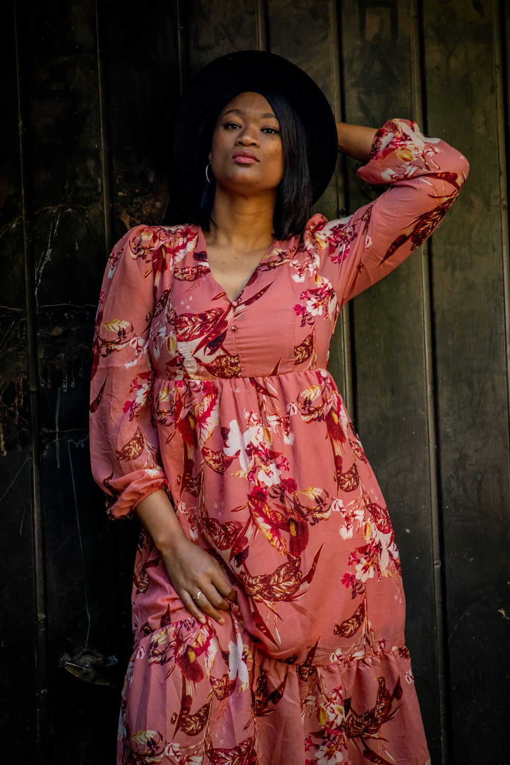 a woman in a pink dress and a black hat