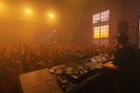 a dj mixing in front of a crowd of people