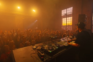 a dj mixing in front of a crowd of people