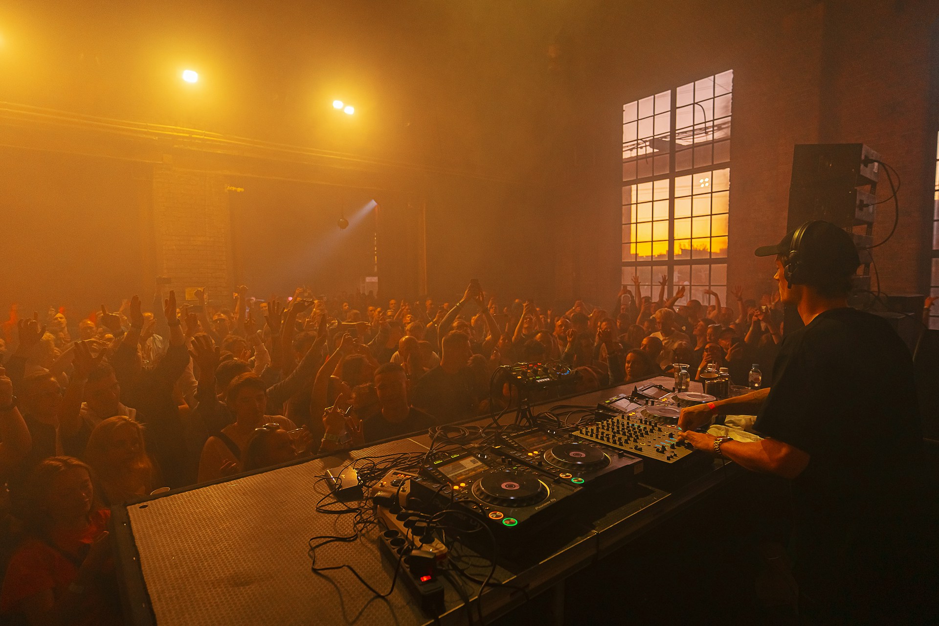 a dj mixing in front of a crowd of people