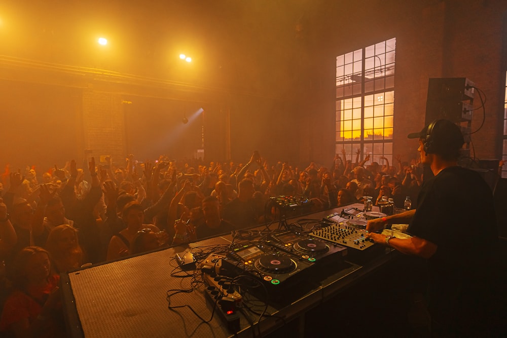 a dj mixing in front of a crowd of people