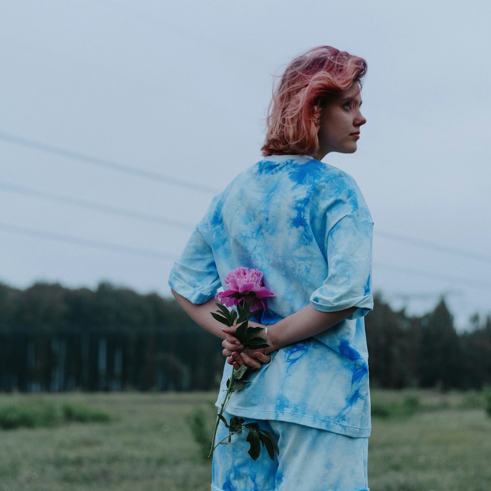 woman in blue and white floral dress holding bouquet of flowers