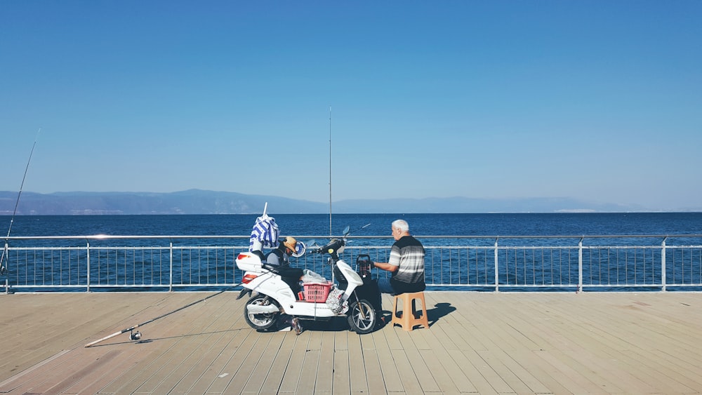 Un uomo e una donna in piedi accanto a uno scooter