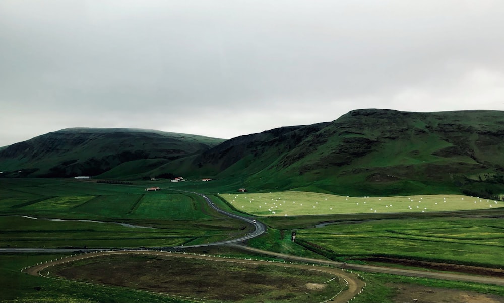 a road winding through a lush green valley