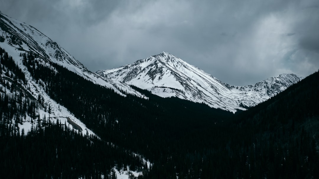 snow covered mountain under cloudy sky