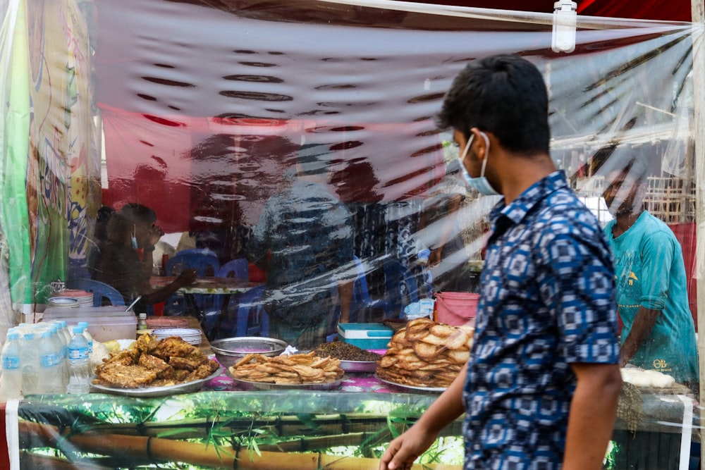 a man standing in front of a display of food