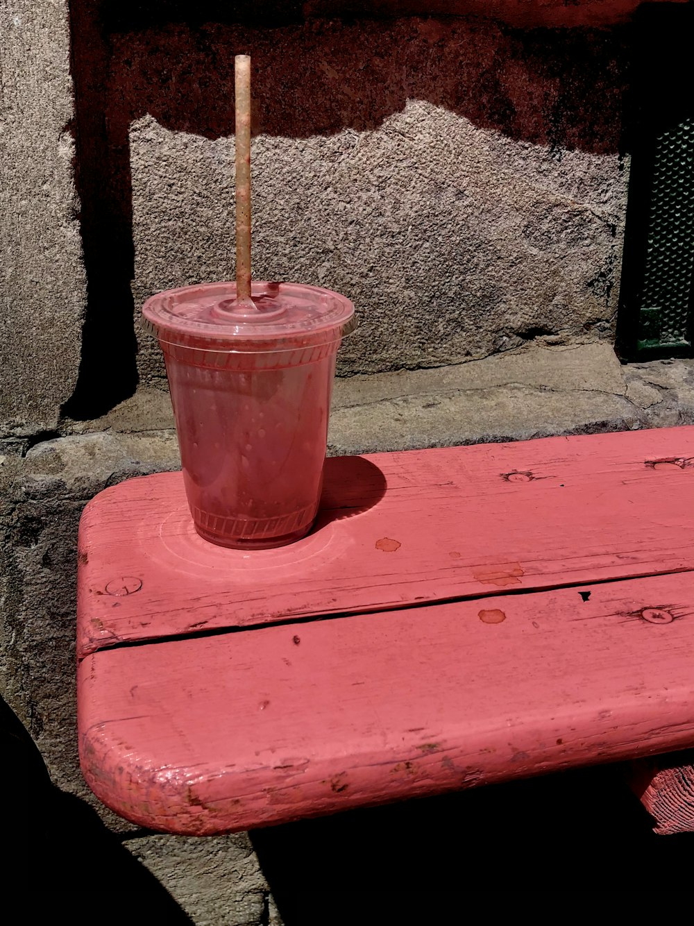 pink plastic cup on red wooden table