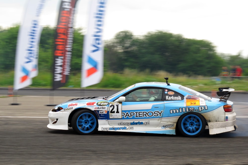 a blue and white car driving down a race track