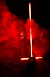 a man in a gas mask holding a light saber