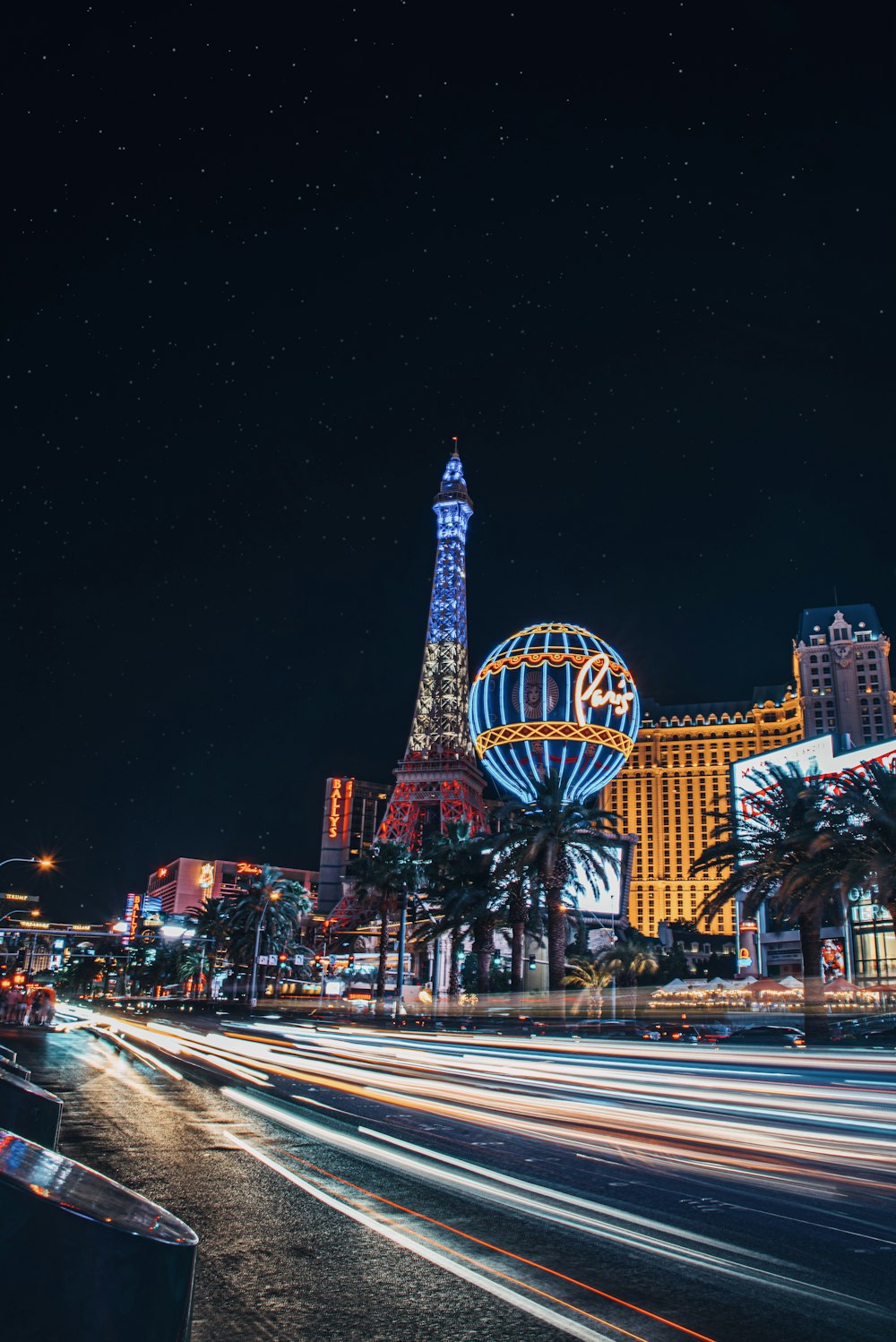 the las vegas strip at night with the eiffel tower in the background