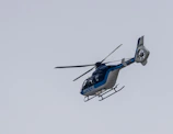 A police helicopter flying over a city during a manhunt operation