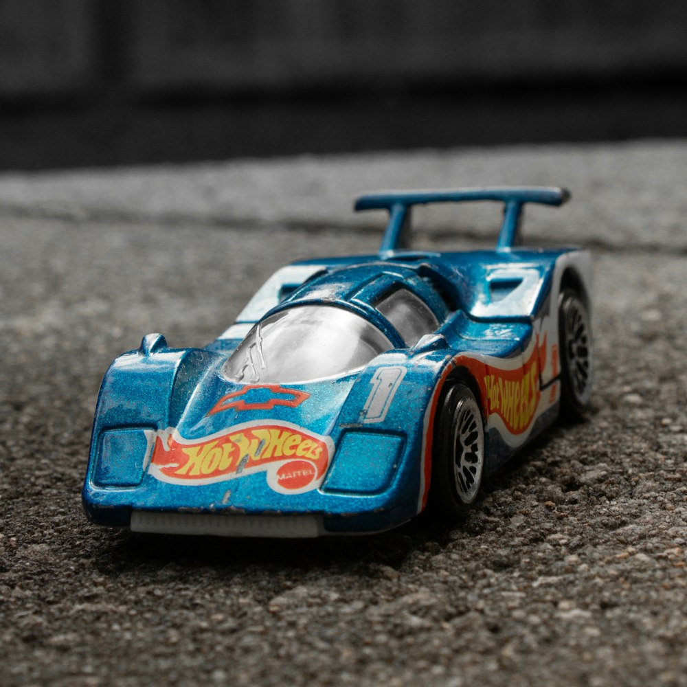 a blue toy car sitting on top of a street