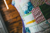 Close-up of hands crafting a patchwork quilt, symbolizing community creativity and heritage.