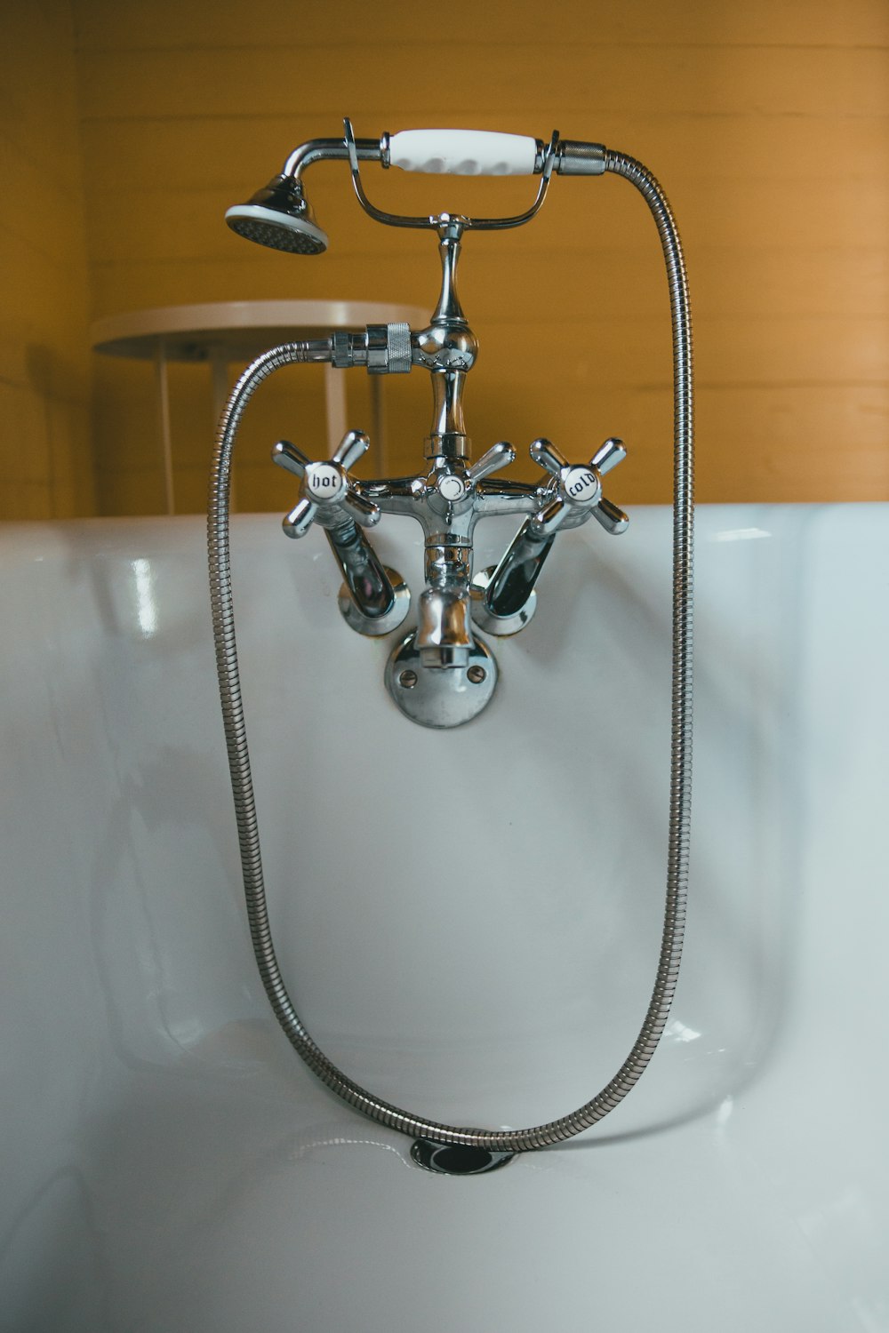 stainless steel shower head on white ceramic bathtub