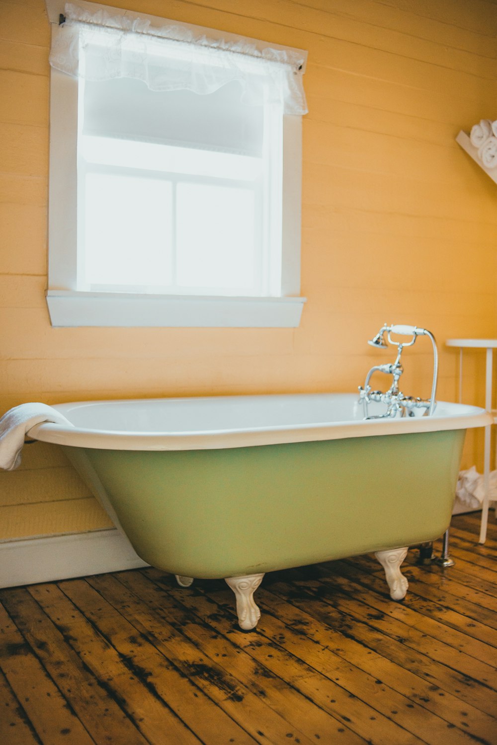 white ceramic bathtub near window