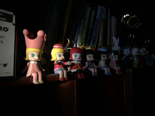A collection of colorful collectible figurines arranged neatly on a shelf with soft lighting.
