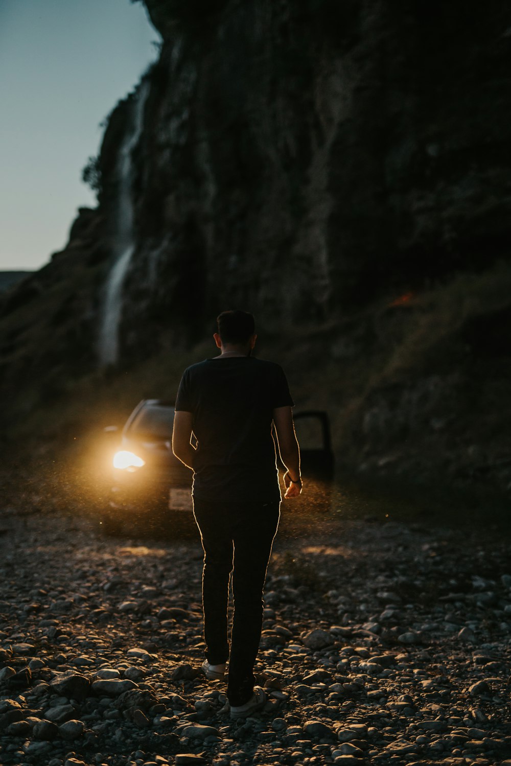 man in black jacket standing on rocky ground during daytime