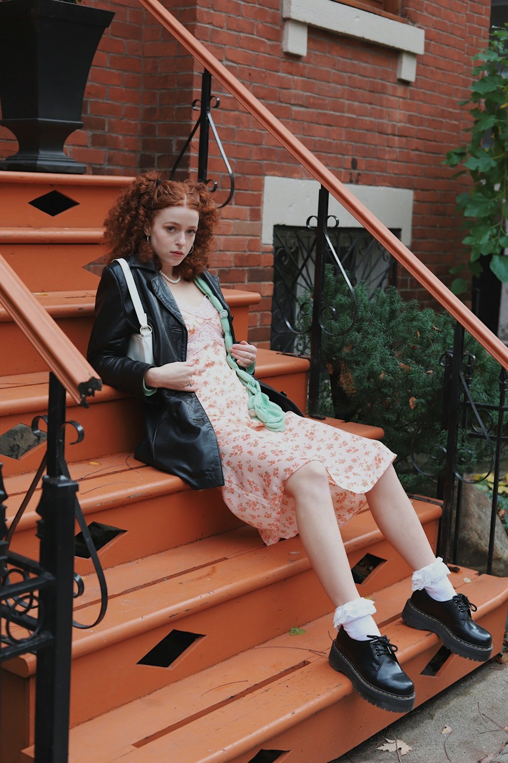 girl in black jacket sitting on brown wooden bench