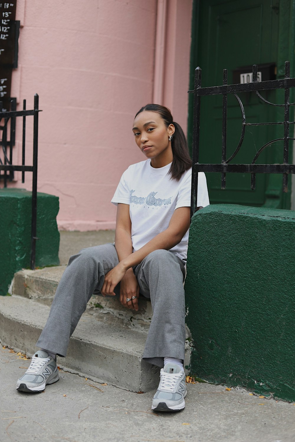 woman in white crew neck t-shirt and blue denim jeans sitting on concrete bench