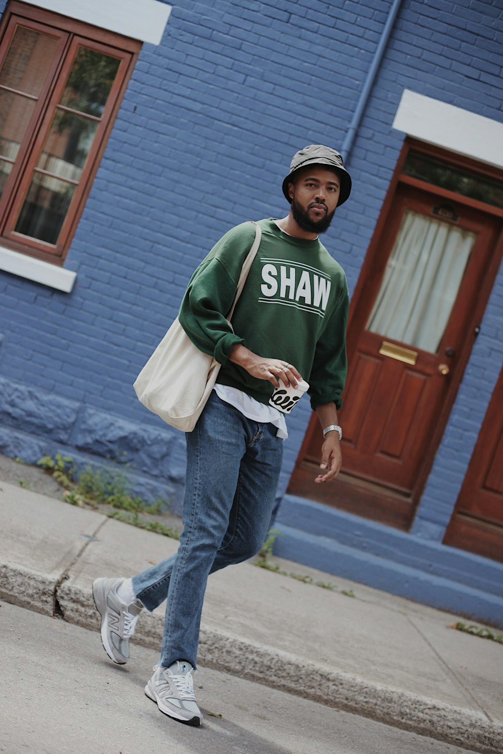 man in green and white crew neck long sleeve shirt and blue denim jeans standing near near near near near