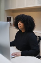 woman in black long sleeve shirt sitting on black and white chair