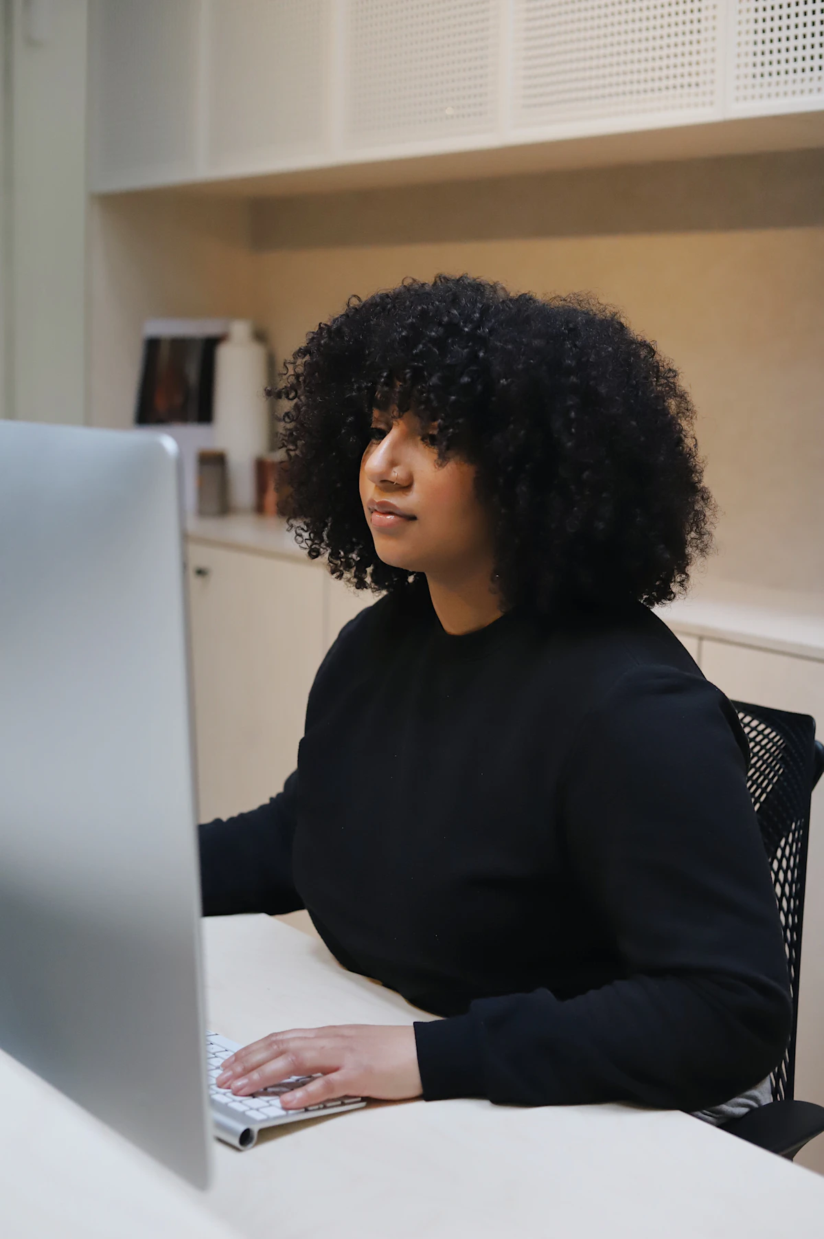 Woman in black long sleeve shirt sitting on black and white chair