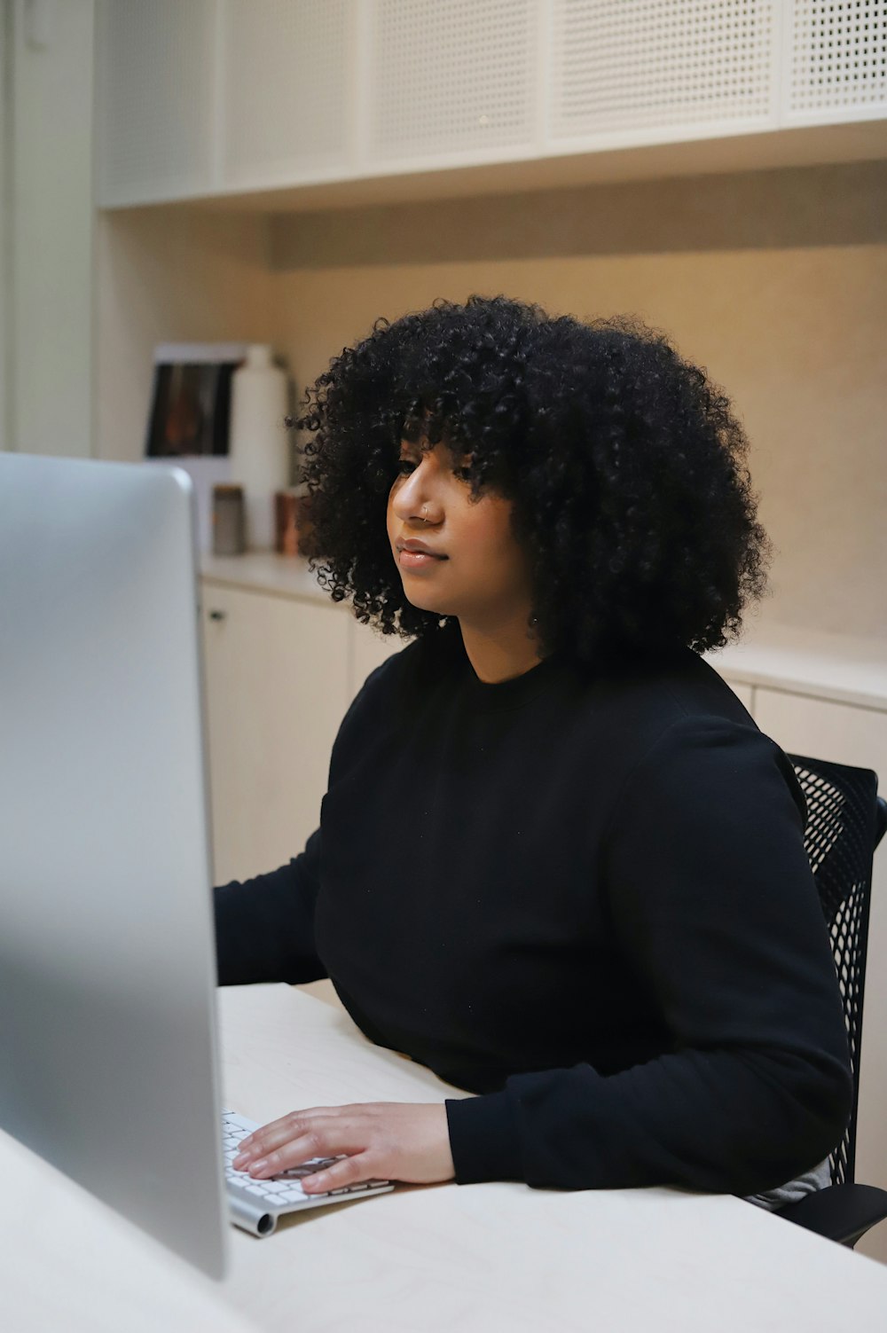 woman in black long sleeve shirt sitting on black and white chair