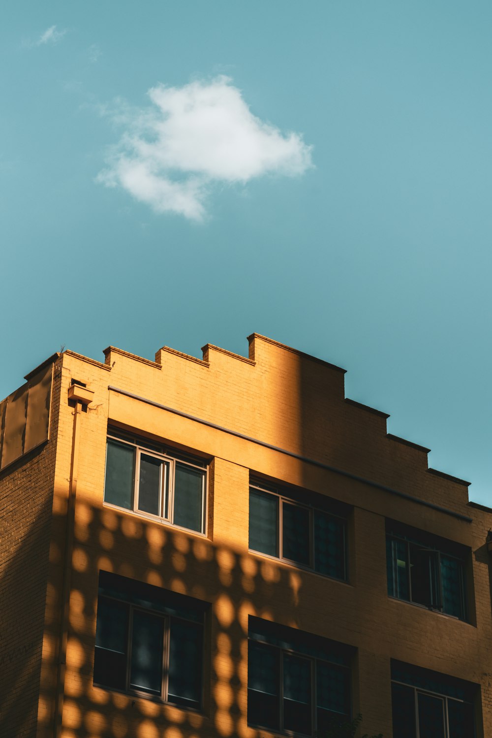 a tall building with windows and a sky background