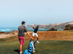 a couple of men standing on top of a lush green field