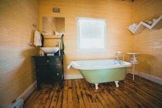 white bathtub on brown wooden floor