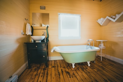white bathtub on brown wooden floor