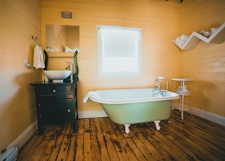 white bathtub on brown wooden floor