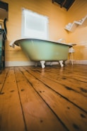 white bathtub on brown wooden floor