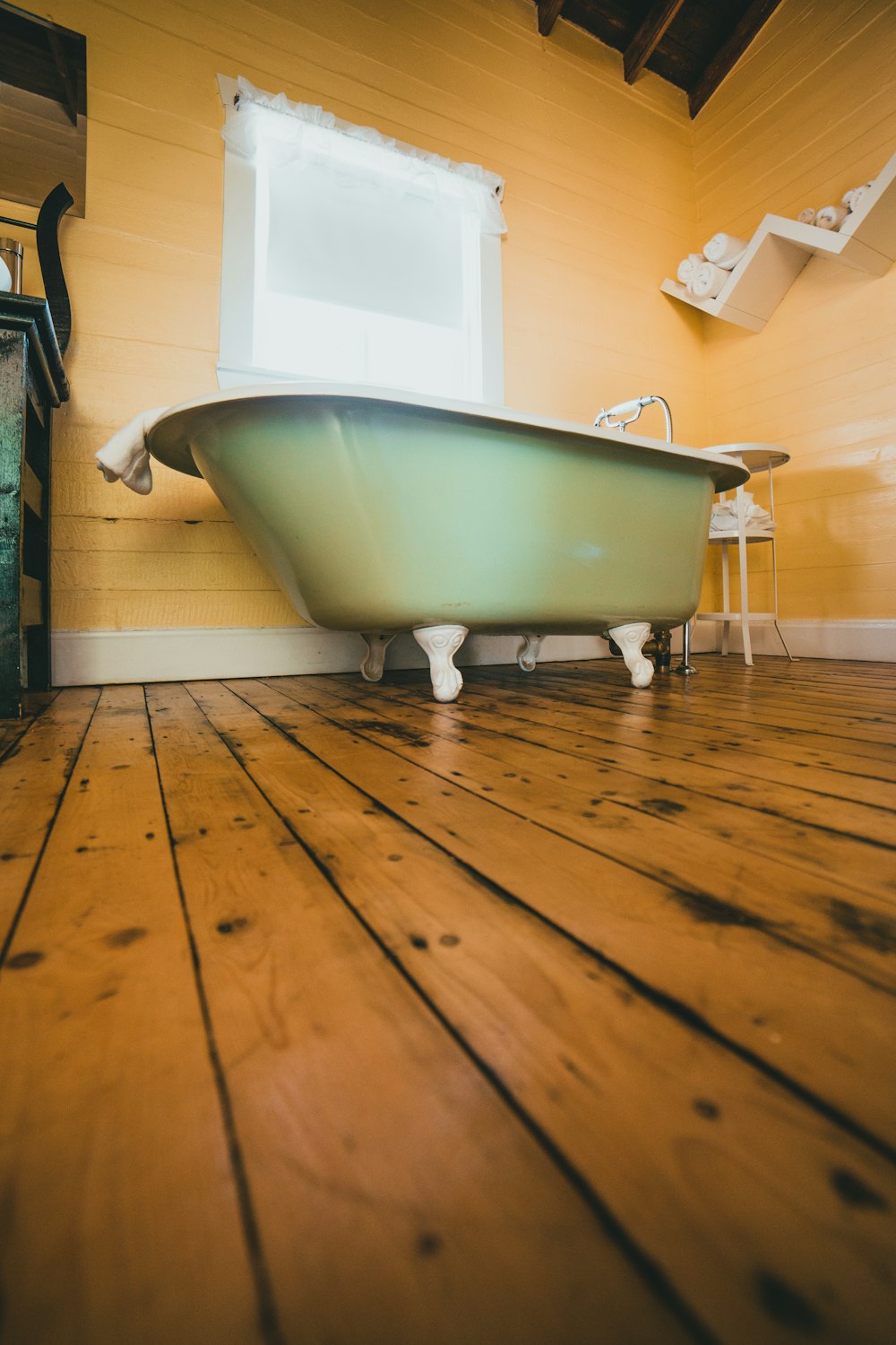 Bañera blanca sobre suelo de madera marrón