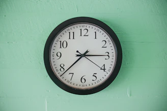 black and white analog wall clock at 10 00