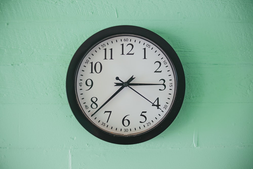 black and white analog wall clock at 10 00