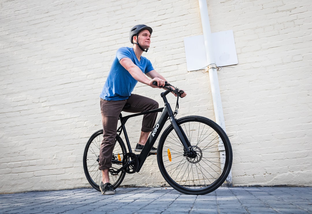 man in blue polo shirt riding black bicycle