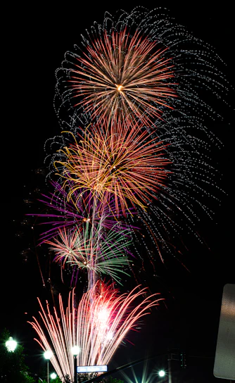 A vibrant fireworks factory workshop with skilled workers assembling colorful fireworks under bright lighting.