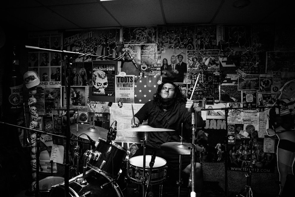 a man sitting in front of a drum set