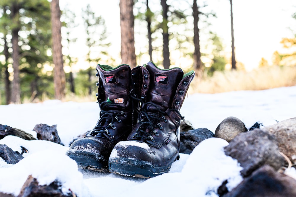 a pair of boots sitting on top of snow covered ground