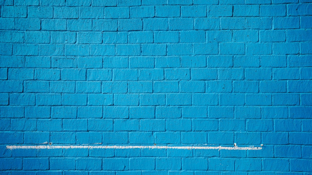 a blue brick wall with a white line painted on it