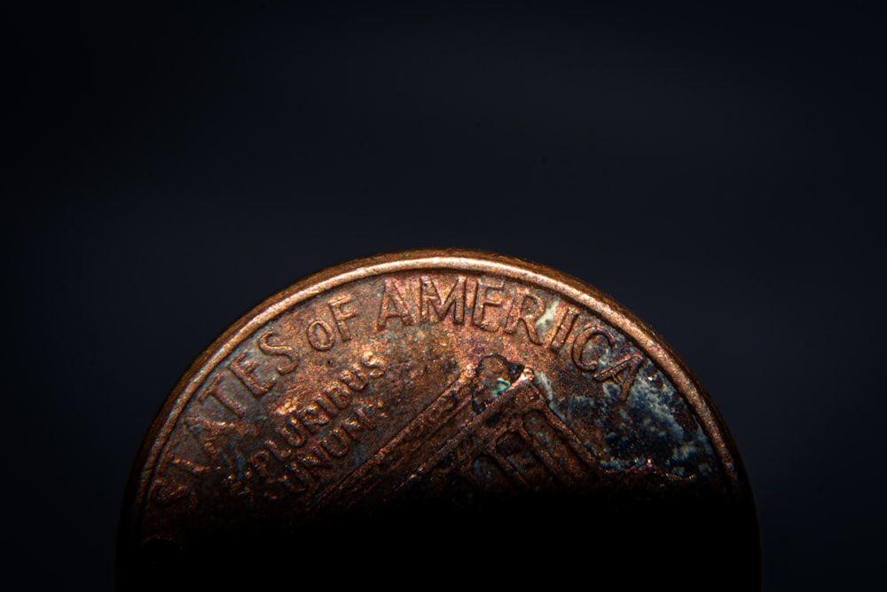a close up of a penny on a black background