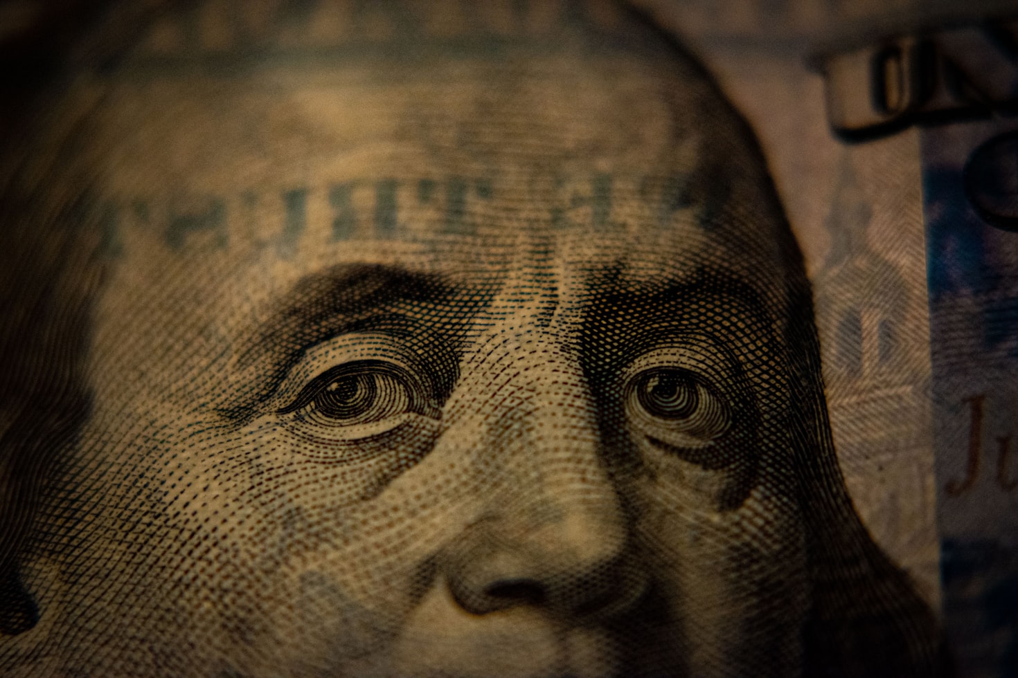 a close-up of a US hundred dollar bill featuring Benjamin Franklin